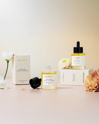 maysaan Arganöl White Musk und Sweet Mandarine – Mobile Bannerbild mit Produkten und Blumen auf beigem Hintergrund. Pflegeöl aus Arganöl für Haut und Haare.