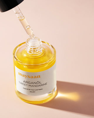 maysaan Arganöl Sweet Mandarine – Glasflasche mit Pipette, Nahaufnahme des goldenen Pflegeöls auf beigem Hintergrund. Pflegeöl aus Arganöl für Haut und Haare.